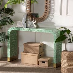 a green console table with baskets under a mirror and potted plants on the floor