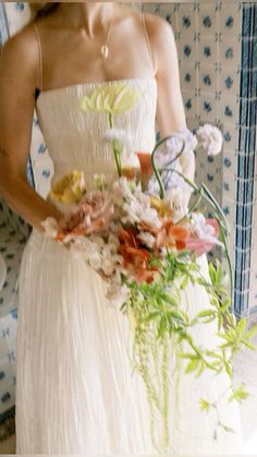 a woman in a white dress holding a bouquet of flowers