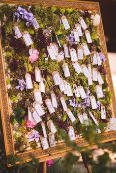 an easel with flowers and tags attached to it