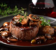 a plate topped with meat and mushrooms covered in sauce