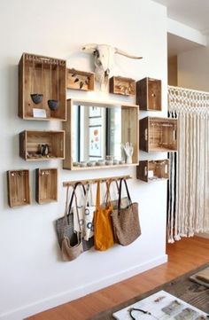 there is a wall with some wooden boxes on it and purses hanging from the hooks