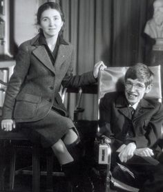 two women and a man standing next to each other in front of a black and white photo