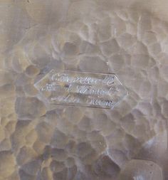 a close up view of the bottom of a vase with some writing on it,