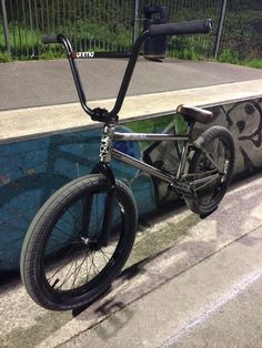 a bicycle parked next to a pool with graffiti on it