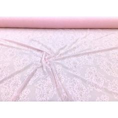 a pink and white bed spread on top of a bed