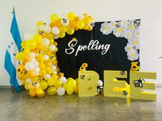 balloons and letters are arranged on the floor in front of a backdrop that says spelling bee