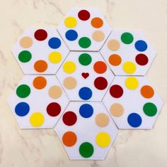 an array of multicolored polka dots arranged in hexagons on a marble surface