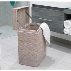 a basket that is sitting on the floor in front of a sink and towel rack