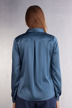 Long sleeve shirt in light stretch silk with collar and buttons up the middle. Back yoke with pleat for a draped, loose fit. Buttoned cuffs and rounded hem. Elegant Blouse With Shirttail Hem And Placket, Elegant Blouse With Placket And Shirttail Hem, Sleek Top With Button Cuffs And Spread Collar, Sleek Top With Spread Collar And Button Cuffs, Elegant Tops With Concealed Placket And Shirttail Hem, Semi-formal Silk Top With Fold-down Collar, Semi-formal Silk Top With Fold Down Collar, Sleek Collared Tops With Concealed Placket, Elegant Blue Blouse With Collared Neckline