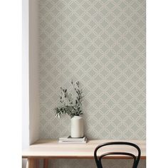 a small table with a plant on it next to a wallpapered wall in a room