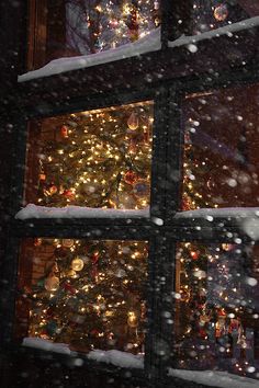 a window covered in snow next to a christmas tree