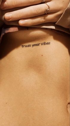 a woman's stomach with the words trust your vibes written on it