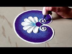 someone is painting a blue and white flower