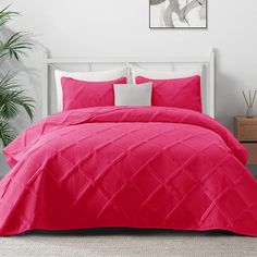 a bright pink comforter set with white pillows