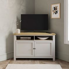 a flat screen tv sitting on top of a wooden cabinet