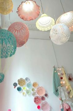 several colorful lights hanging from the ceiling in a room with white walls and flooring