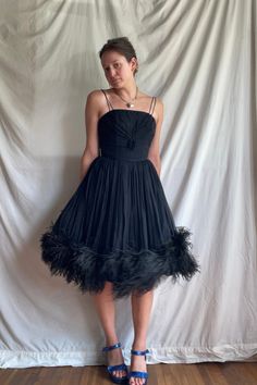 Step into timeless elegance with this vintage-inspired empire waist cocktail dress. Embrace the allure of the 1950s and 1960s with a touch of modern sophistication, reminiscent of Bob Mackie's glamorous designs. Twirl on the dance floor and feel the ethereal charm of the ostrich feather trim. You'll shine like a star from a bygone era, leaving everyone mesmerized! Elevate your style with this classic chic statement piece.  CONDITION: MINT MEASUREMENTS:  bust: 15" waist: 13" hips 27" length: 35" Cocktail Mini Dress, Ostrich Feather Trim, Feather Trim, Bob Mackie, Ostrich Feather, Bygone Era, Mini Cocktail Dress, Classic Chic, Ostrich Feathers