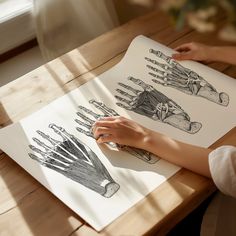 a person is drawing on paper with their hands