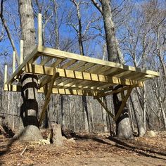 a wooden structure sitting in the middle of a forest