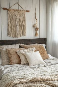 a bed that has some pillows on top of it and two macrame wall hangings above the headboard