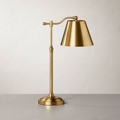 a gold lamp on a table with a white wall in the background