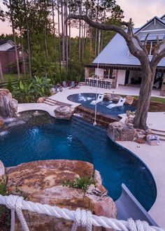 an outdoor swimming pool surrounded by rocks and trees