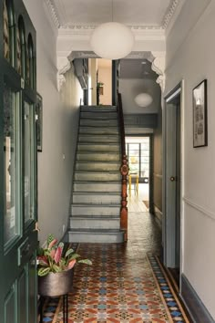 a hallway with stairs and tiled flooring