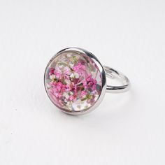 a ring with pink flowers in it on a white surface