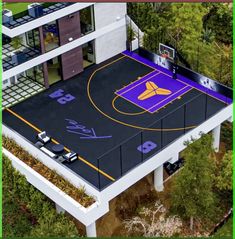 an aerial view of a basketball court in the middle of a building with cars parked on it