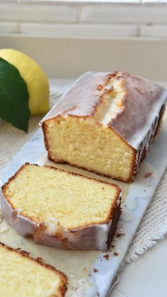 a loaf of lemon pound cake on a cutting board with two slices cut off the side