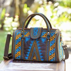 Named after the beautiful Banda region of Indonesia this handle handbag is designed by Balinese artisan Anita Jo. The black cotton handbag features beautiful saffron and teal hand embroidery that creates triangular swirl and zigzag patterns in the traditional style of the Banda Aceh province which was hit by a devastating tsunami in 2004. Opening with a zipper the handbag reveals a black lined interior complete with a zipper pocket on one side for storing small items. Traditional Tote Bag With Top Carry Handle, Traditional Satchel With Double Handle For Daily Use, Traditional Satchel For Daily Use With Double Handle, Traditional Top Handle Satchel For Daily Use, Embroidered Brown Tote Satchel, Brown Embroidered Tote Satchel, Brown Embroidered Handheld Shoulder Bag, Traditional Tote Shoulder Bag With Top Handle, Travel Satchel With Embroidered Double Handle