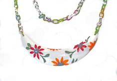 "This cheerful necklace adds some whimsy to one's jewelry wardrobe. The flowers on the pendant and the multi colored chain complete the look of a garden. The necklace reminds one of a playful fun filled sunny day.  Spring time and summer time dresses have colors that are cheerful and bright. The dress is enhanced with this matching flower themed necklace. Doing to a beach wedding? This is a perfect accessory. The pendant is large and is half moon shaped with orange and red flowers on a white background which makes the colors pop. The chain the has baked in colors to match the pendant. Spring time jewelry is always in vogue to cheer up the office wear and a party dress. The inspiration for creating it, is the love of flowers and gardens.  Dimensions: Necklace: 24\"; Pendant: 4 1/2\"; Chain: Gardner Gifts, Team Unity, Garden Of Flowers, Promotion Party, Time Jewelry, Fleur Orange, Amazing Finds, Jewelry Wardrobe, Painted Flower