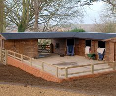 a horse stable with two stalls on each side and a ramp leading up to it