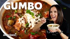 a woman is holding a bowl of gumbo soup