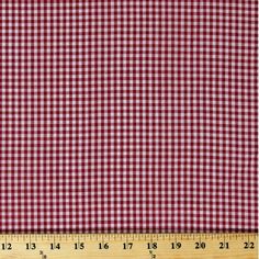 a red and white checkered fabric with a ruler in front of it, showing the width