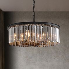 a chandelier hanging from the ceiling with clear glass tubes and lights on it