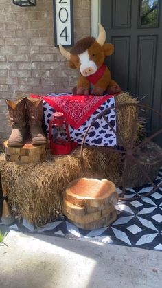 a cow statue sitting on top of hay next to a door