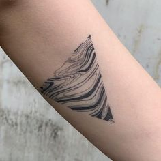 a black and white tattoo on the arm of a person's arm with wavy lines