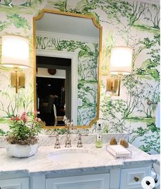 a bathroom sink with a mirror above it next to a wallpapered wall and vanity