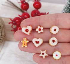 small miniature food items are displayed in the palm of someone's hand, next to a christmas tree