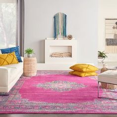 a living room filled with furniture and a pink rug