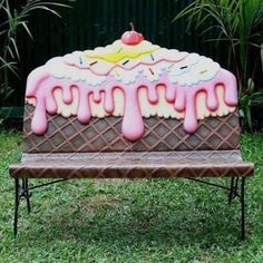 an ice cream covered bench sitting in the grass