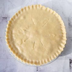 an uncooked pie crust on a marble surface