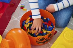 a child is playing with legos in a bowl