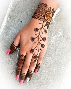 a woman's hand with hennap and flowers on the top of it