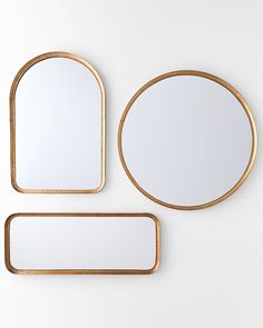 three mirrors on the wall and one is gold