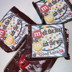 three chocolate bars with m & m's on them sitting next to each other