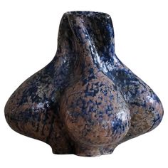 a brown and blue vase sitting on top of a table