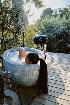 a woman sitting in an outdoor bath tub