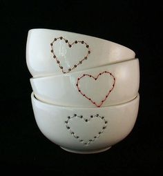 three white bowls with hearts painted on them